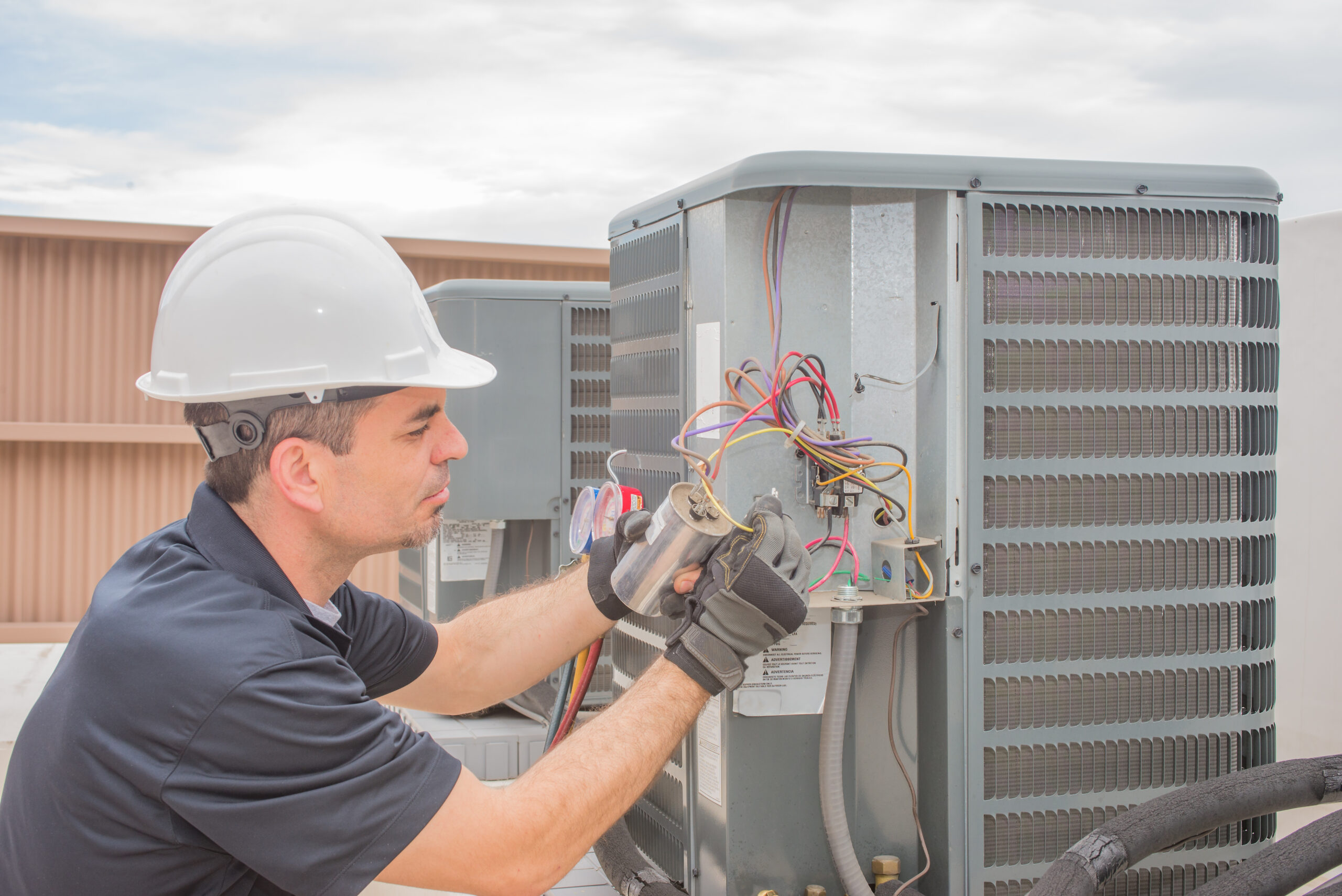 HVAC technician working on a capacitor part for condensing unit